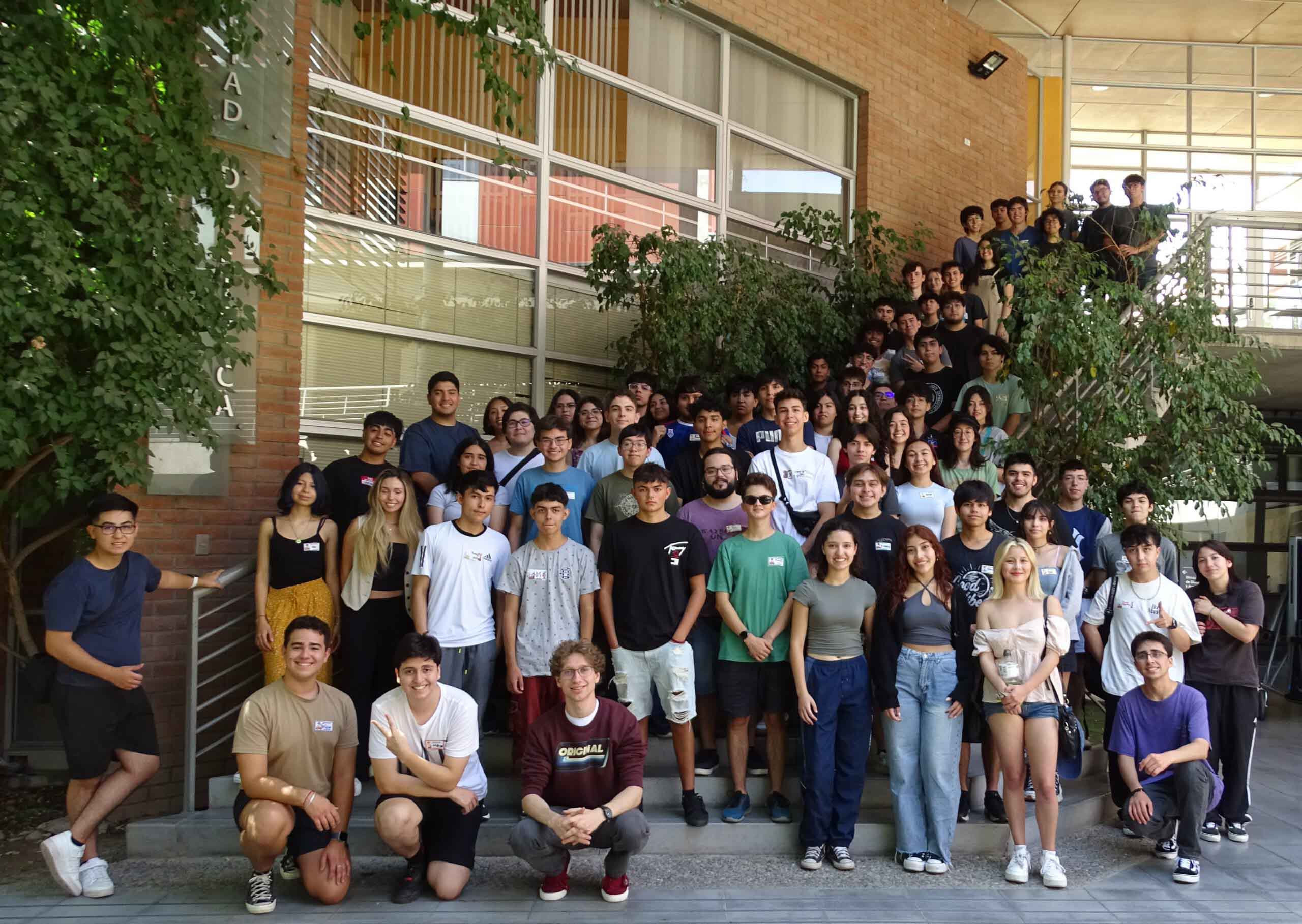 grupo de estudiantes posando en la universidad frente a un edificio.